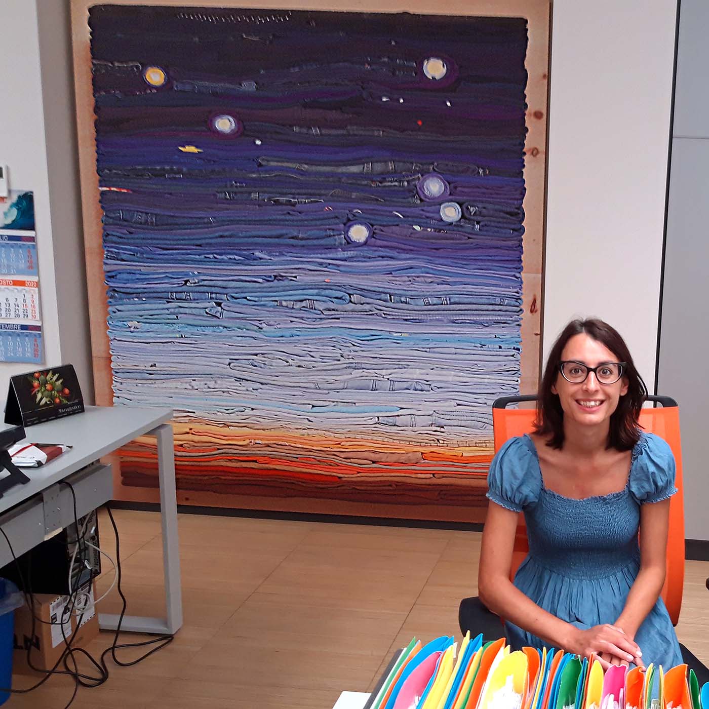 Image of Giorgia Lera in her office with Night Sky, textile art by Derick Melander